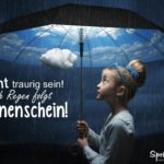 Mädchen mit Regenschirm im Regen. Unter dem Schirm scheint die Sonne