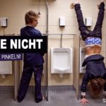 Nicht im stehen pinkeln - Mann macht Handstand am Pisuar