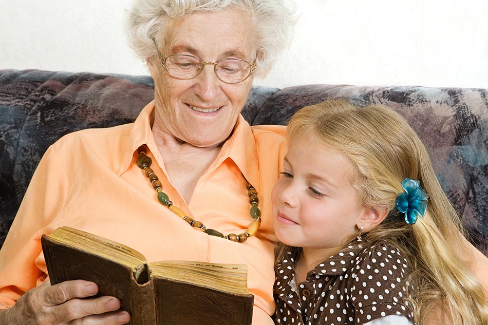 Oma liest Enkelin ein Märchen vor