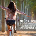 Glückliches Mädchen freihändig auf dem Fahrrad fährt durch Allee