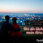 Pärchen auf Hügel vor Stadt - Liebe und lächeln Spruch